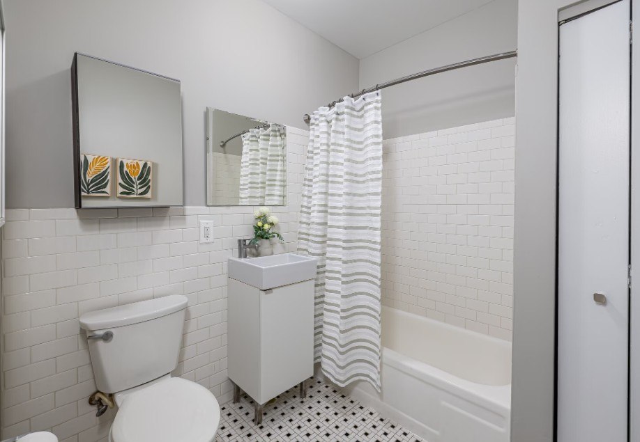 A white toilet sits next to a white sink in a bathroom.